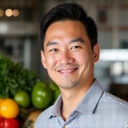 Marcus Chen, a certified nutrition specialist, in a kitchen setting with fresh produce.